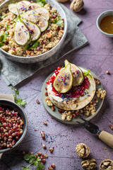 tasty healthy dish with figs fruits, nuts, honey, camembert cheese, couscous and pomegranate seeds and figs