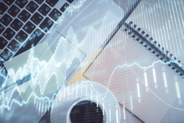Stock market graph and top view computer on the table background. Double exposure. Concept of financial education.
