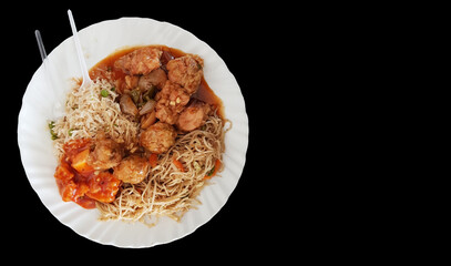 chinese food noodle and chilli chicken gravy on a plate with black background with space for text