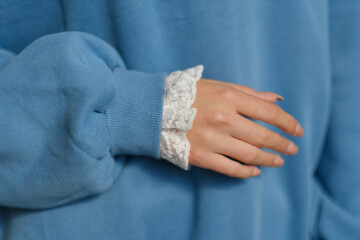 details of sleeves of fashionable blue sweatshirt on model.