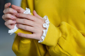 Fototapeta premium details of sleeves of fashionable yellow sweatshirt on model.