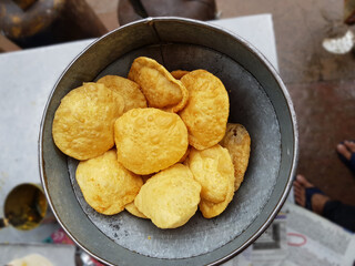 fried food kachauri puri pile deep fried in oil in a big aluminium container