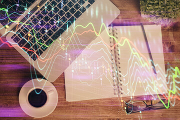 Financial market graph and top view computer on the desktop background. Double exposure. Investment concept.