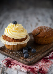 
Fresh muffins and blueberries on a wooden table