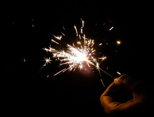 burning of hand held sparkle firework in black background