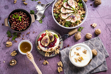 top view of gourmet dish with Figs fruits, nuts, honey, couscous and pomegranate seeds on table