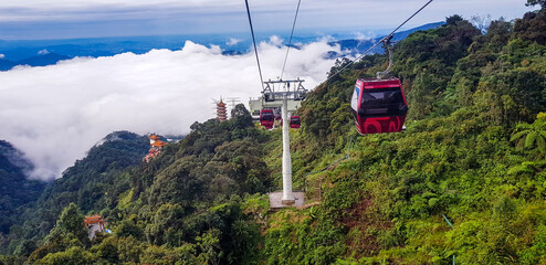 cable car at genting highlands, malaysia in a foggy weather with green grass visible from inside cable car