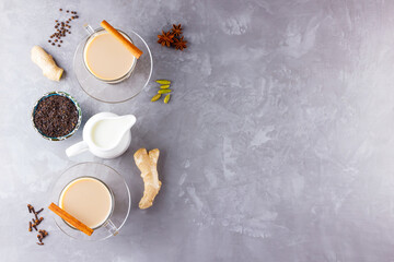 Obraz na płótnie Canvas Masala chai tea. Traditional indian drink - masala tea with spices on gray background. Copy space. Top view