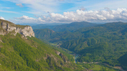 Fototapeta na wymiar AERIAL: Flying over a spectacular forest covered valley in Slovenian countryside