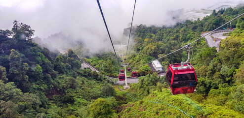 cable car at genting highlands, malaysia in a foggy weather with green grass visible from inside...