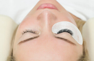 Obraz na płótnie Canvas Eyelash extension procedure. A woman's eye with long lashes. Lashes, close-up, macro, selective focus.