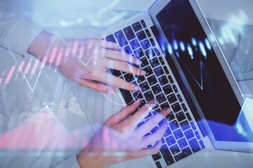 Double exposure of woman hands working on computer and forex chart hologram drawing. Top View. Financial analysis concept.