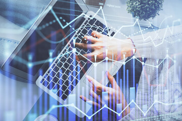 Double exposure of woman hands working on computer and forex chart hologram drawing. Top View. Financial analysis concept.