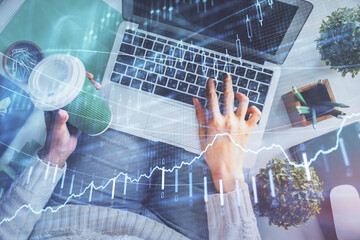 Double exposure of woman hands working on computer and forex chart hologram drawing. Top View. Financial analysis concept.