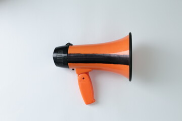An orange loudspeaker is shown against a white background