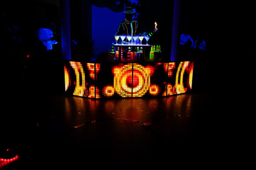 Professional barman and led light show. Silhouette of modern bartender shaking drink at night...