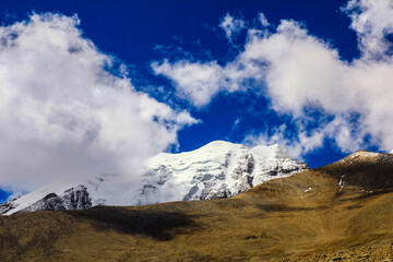 Landscape of deep blue sky and ice capped peaks of himalayan mountains with white clouds during day time