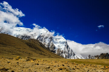 Landscape of deep blue sky and ice capped peaks of himalayan mountains with white clouds during day time