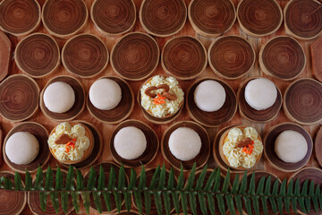 white delicate lowly macaroons on a wooden background. The pastel tone of the cream inside the French cookies