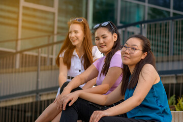Portrait of the three female students. Asian young woman on front with two blurred women on background. Chinese student.