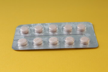 Pills in packaging on a yellow background