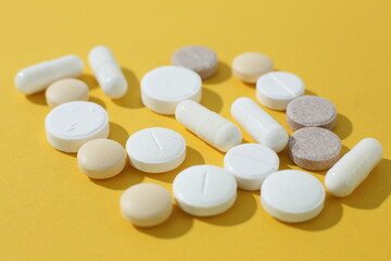 Obraz na płótnie Canvas Pills and tablets on yellow background