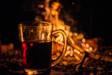 Transparent glass with a drink on the background of fire. Grain and Noise vintage edition.