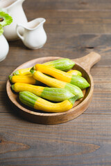 Fresh Zephyr Squash in a Wooden Bowl on a Wooden Table