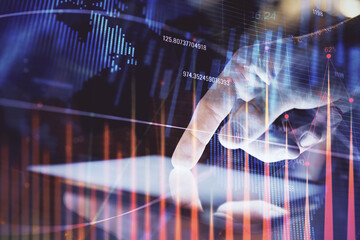 Double exposure of man's hands holding and using a digital device and forex graph drawing. Financial market concept.