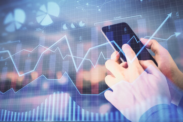 Double exposure of man's hands holding and using a digital device and forex graph drawing. Financial market concept.