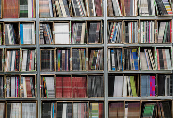 Neatly stacked records sit in rows on shelves at a warehouse ready for sale or distribution.	
