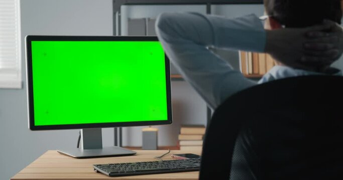 Relaxed woman holding hands behind head while sitting comfortably on chair and looking at blank computer screen. Mature lady having break at office during working process.