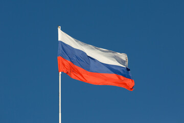 Russia flag is on a pole against a blue sky - 378448021