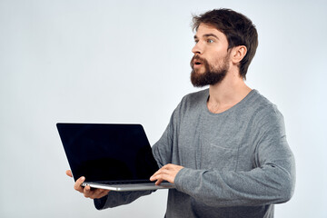 A man in a gray sweater with a laptop hands lifestyle technology communication internet work