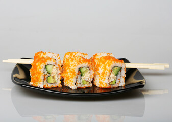 japanese rolls on black plate.