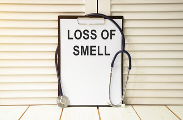 Anosmia, loss of smell. Loss of smell text on white paper and stethoscope around.