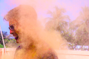 a man getting showered with holi colours during holi festival in india