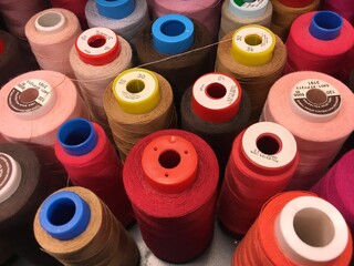 Set of sewing threads of varieties of color red. Threads of shades of red and brown on spools. Sewing materials