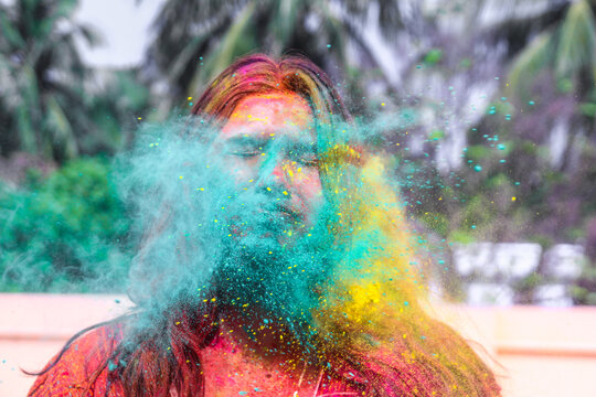 a lady getting showered with holi colours during holi festival in india