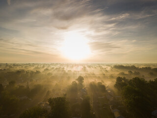 Early morning fog blankets a suburban neighborhood after a night of damaging storms as seen from an aerial drone image