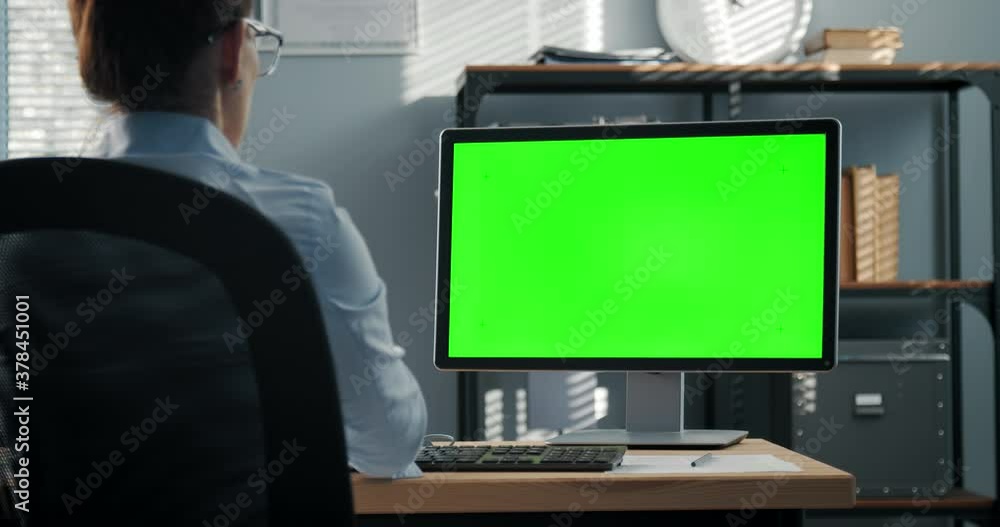 Poster view from shoulder of confident woman in blue shirt using modern computer for work at office. focus 