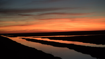 Sunset over a stream in a field