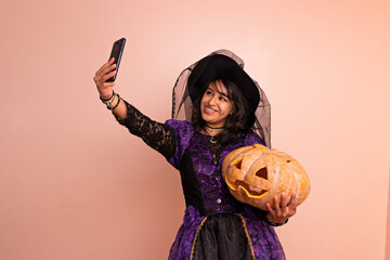 A woman dressed in a witch costume taking a selfie