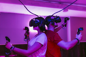 The guy and the girl play virtual reality games. Neon game room.