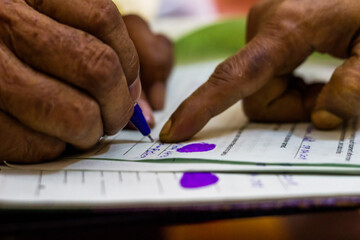 old man signing on an imoirtant legal document as instructed