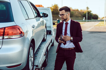 Elegant middle age business man calling towing service for help on the road. Roadside assistance...