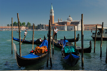 Fototapeta na wymiar Gondoliers on Giudecca Canal in front of San Giorgio Maggiore in Venice