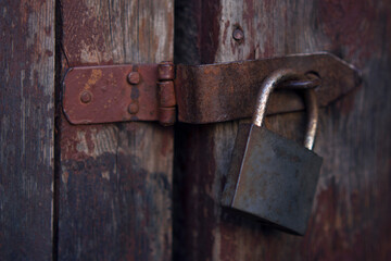 old rusted padlock on the wooden vitage door in countryside