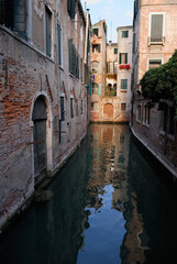 Fototapeta na wymiar Narrow side canal with evening light in Venice