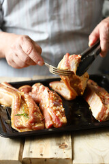 Marinated pork ribs on a pan. The chef marinates pork ribs. Barbecuing ribs.